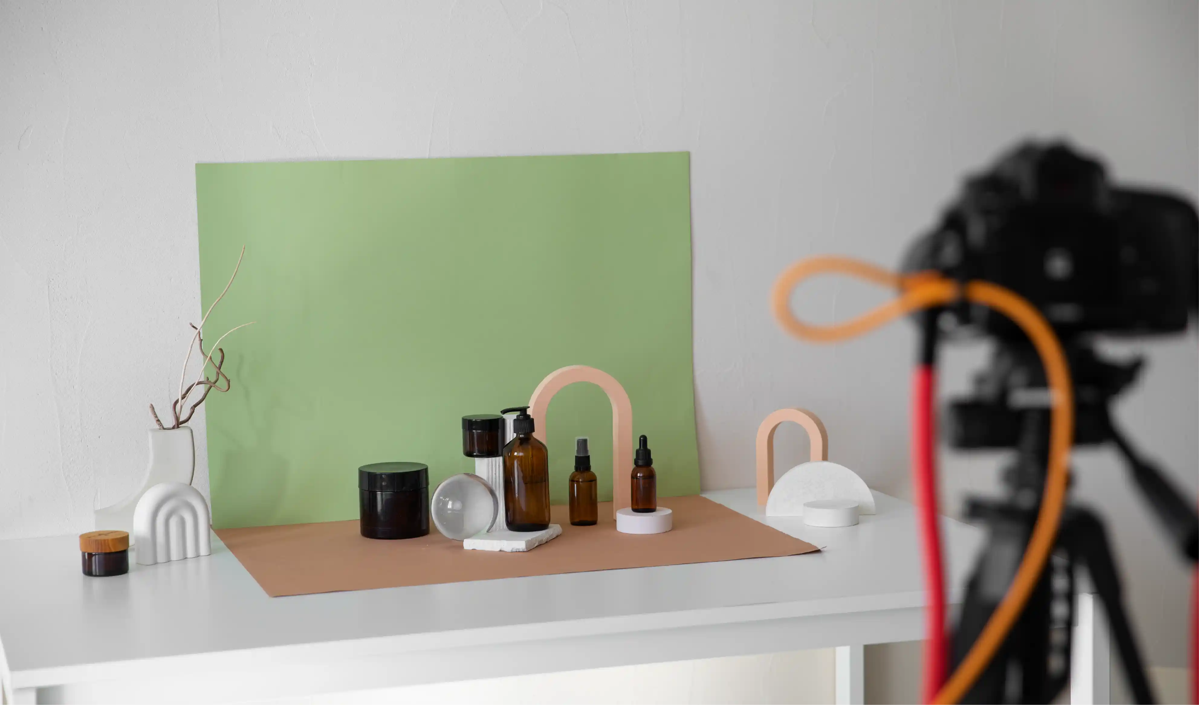 Setup profesional de fotografía de producto con cámara, iluminación y productos sobre mesa